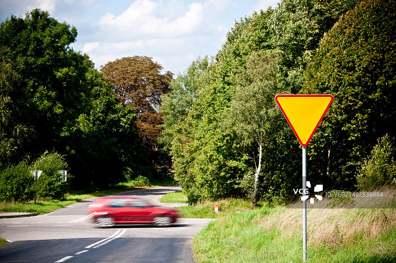 十字路口附近的让行标志和行驶的汽车图片素材