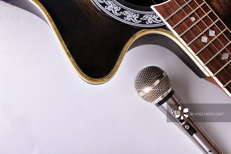 白色桌面上的原声吉他和麦克风俯视图图片素材