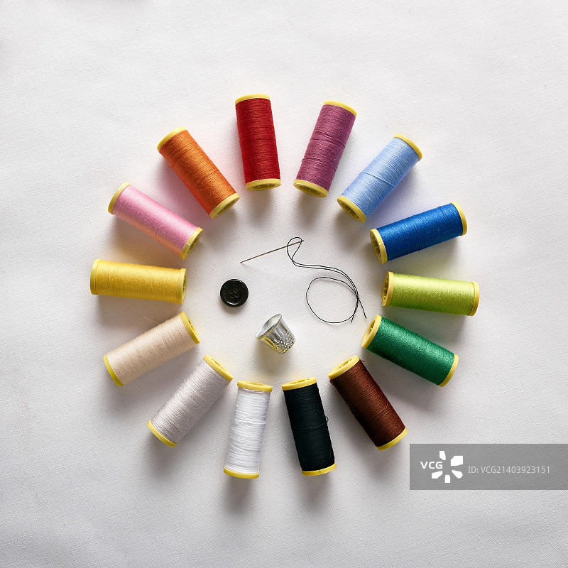 带有针、顶针和按钮的圆形线轴图片素材