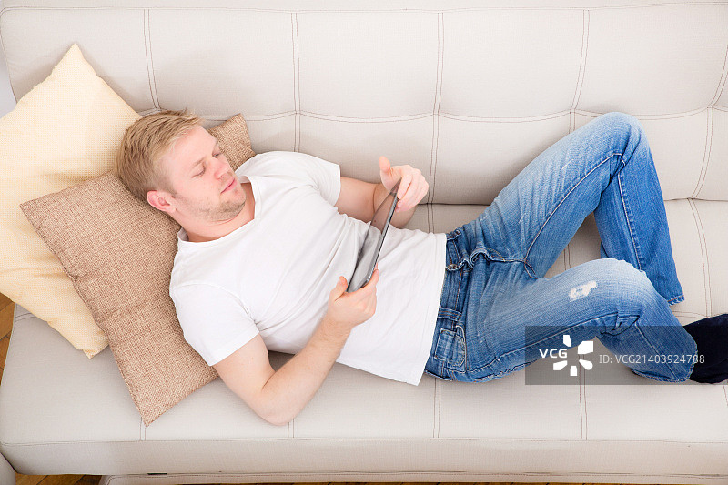 在家使用平板电脑的年轻男人图片素材