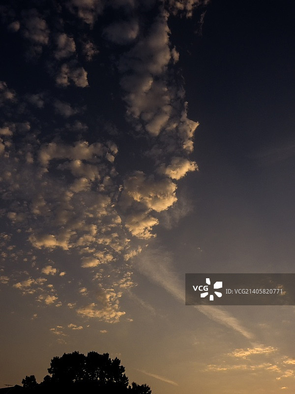 高积云和凝结尾迹预示着六月的日出！图片素材