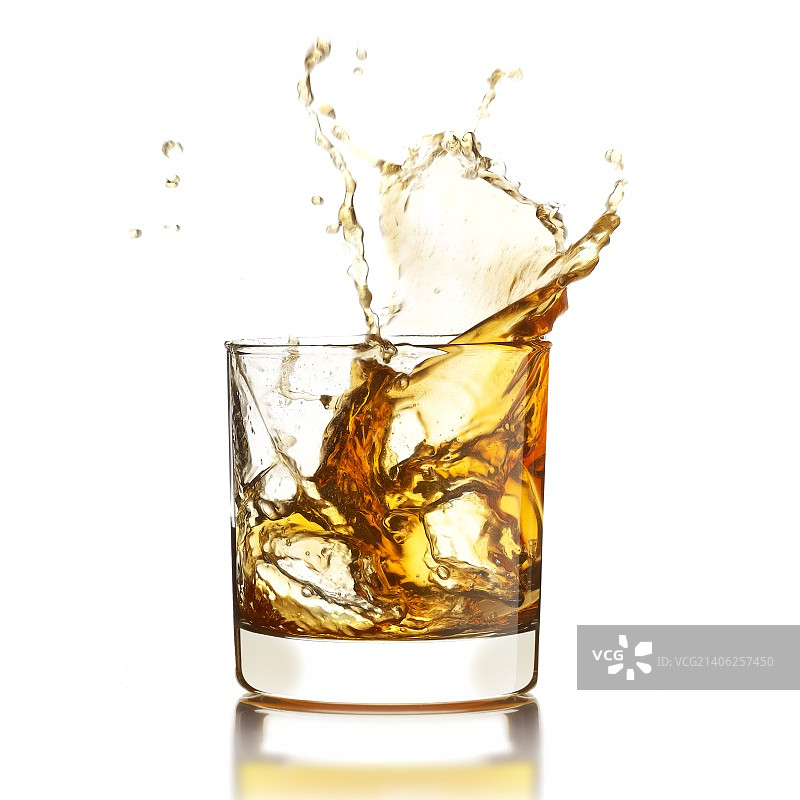 威士忌与冰块飞溅出玻璃杯图片素材