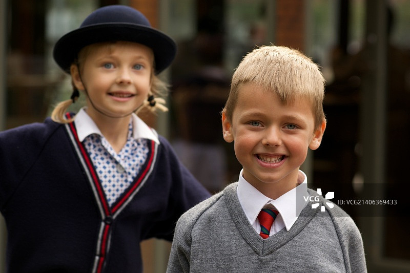 微笑的男学生站在妹妹面前图片素材