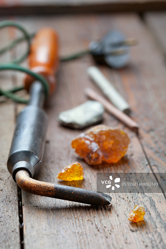 木桌上的旧焊锡枪、松香和焊料图片素材