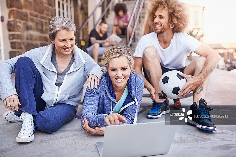 朋友们用笔记本电脑一起玩足球图片素材