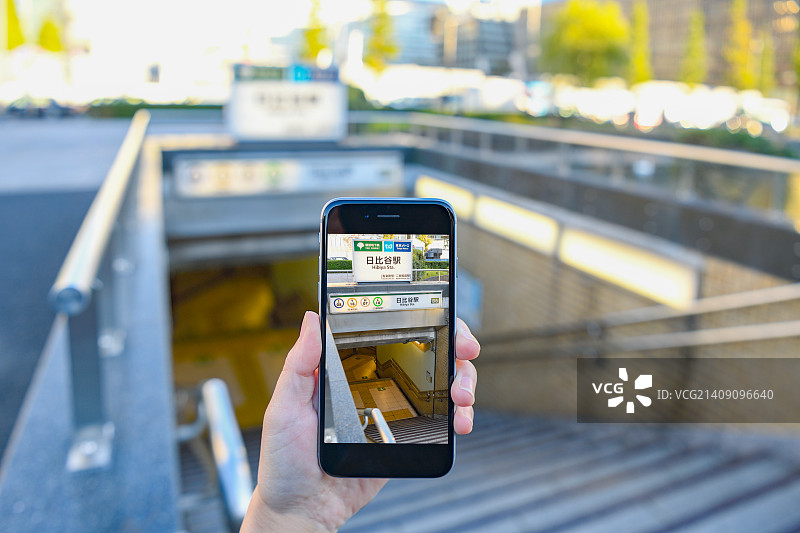 在东京商业区使用增强现实APP的日本女性图片素材