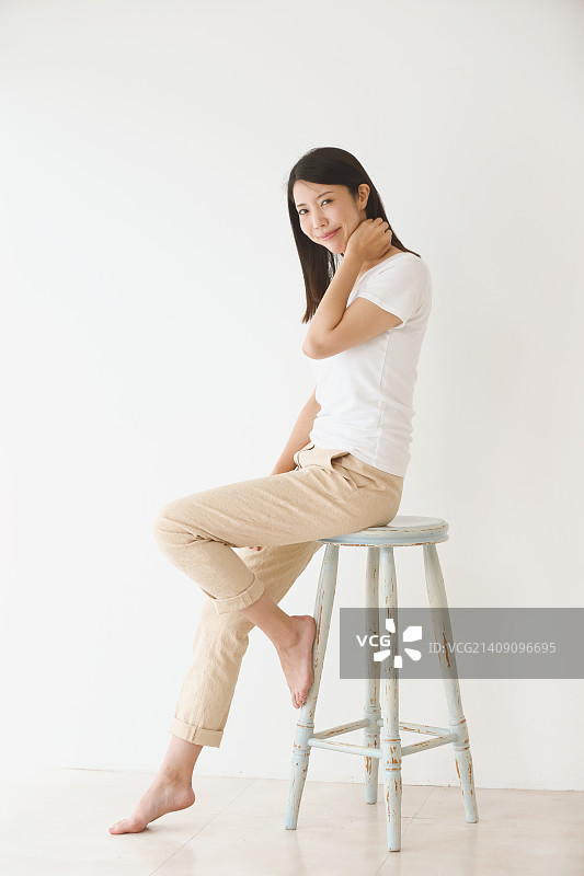 坐在白色房间椅子上的年轻日本女子图片素材