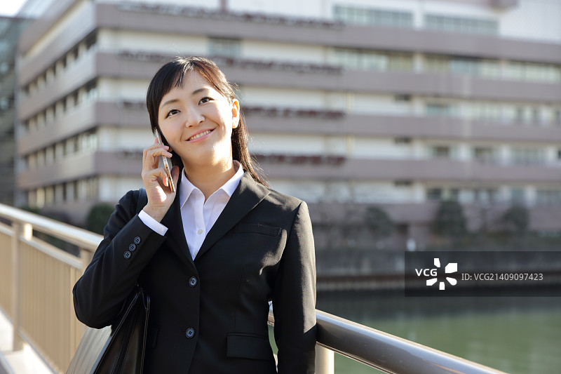 在东京市区打电话的日本年轻女商人图片素材