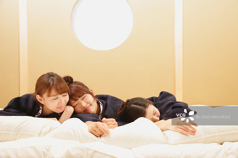 在传统日式旅馆卧室里穿着浴衣的年轻日本女性图片素材