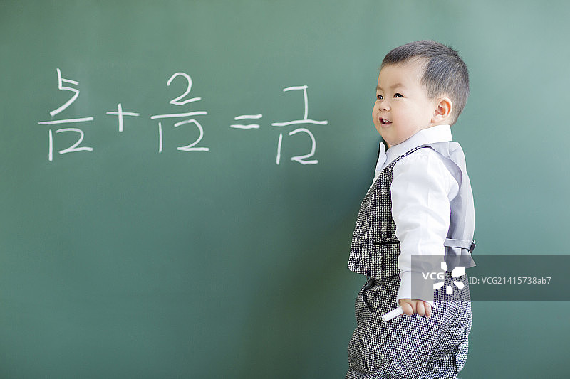 可爱的宝宝在黑板上做数学题图片素材