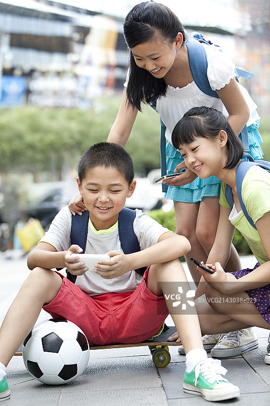 小学生一起玩智能手机图片素材
