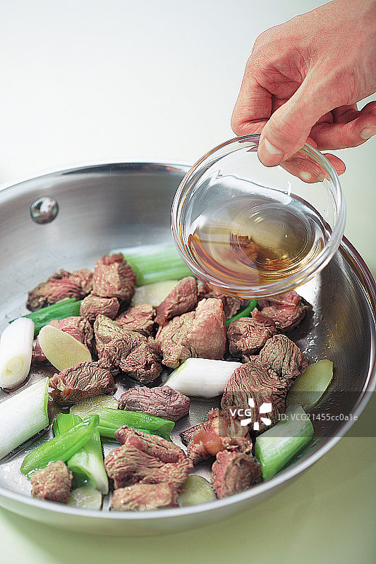 土豆烧牛肉步骤—倒入料酒图片素材