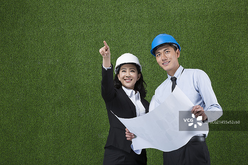 草地商务设计师拿着图纸指向远方图片素材