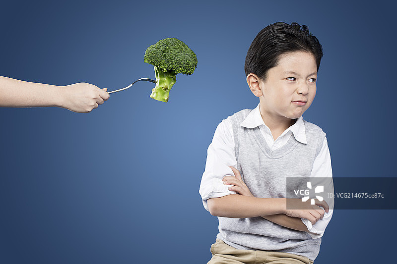 在蓝色背景下穿灰色背心的小孩图片素材