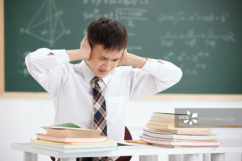 一个中学生在教室里手捂耳图片素材