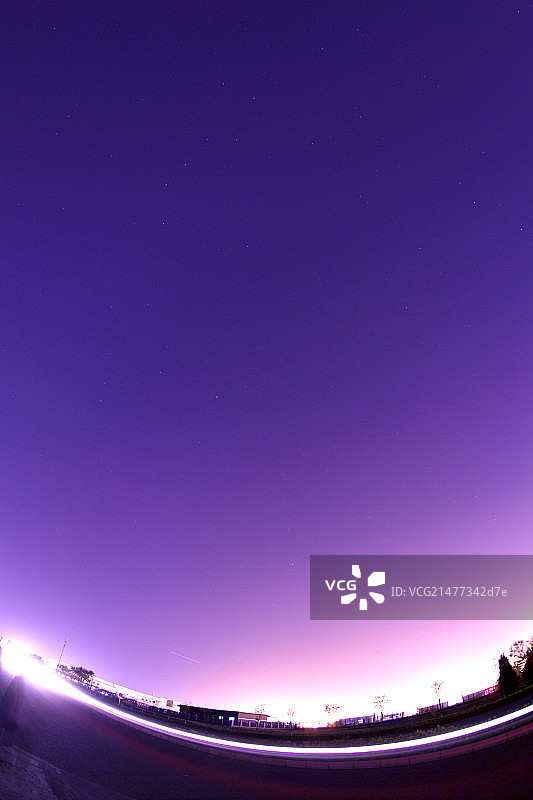 一架正在起飞中的飞机的灯光在夜空中形成了美丽的弧线图片素材