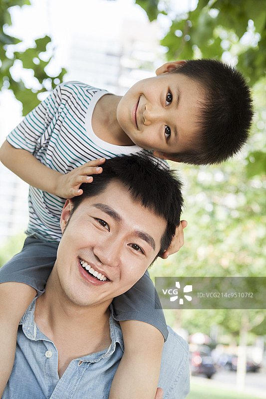 小男孩坐在爸爸肩上图片素材