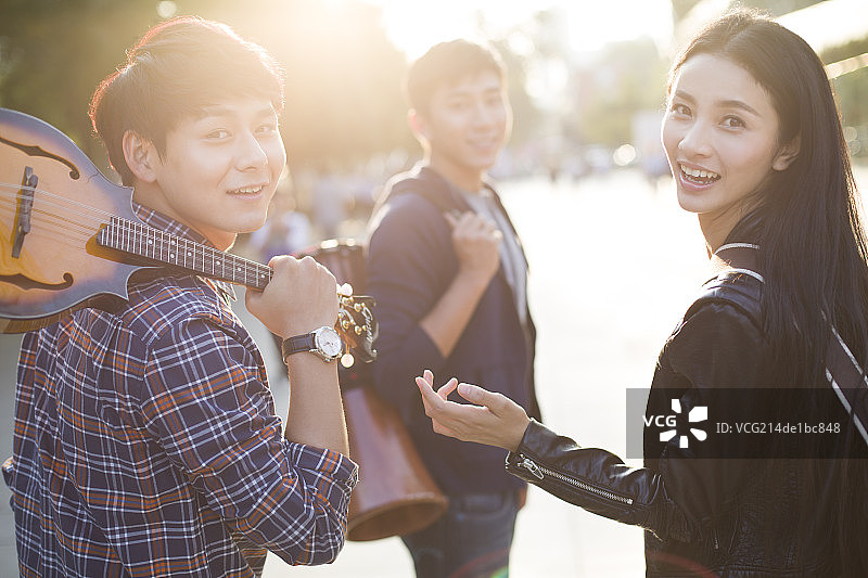 年轻人带着乐器离开图片素材