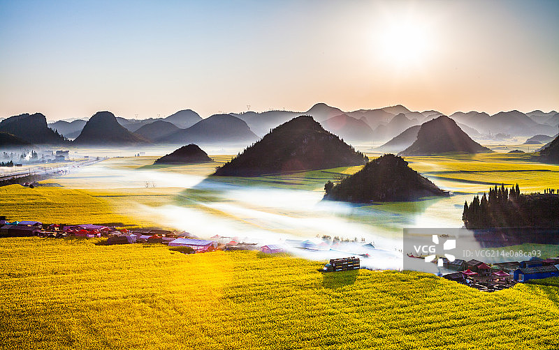 罗平油菜花田的炊烟图片素材