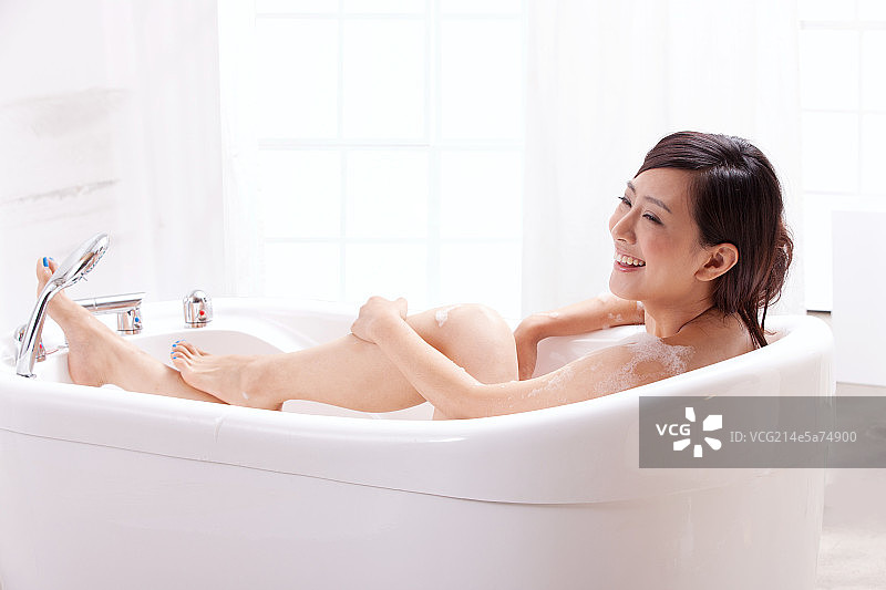 一个年轻女人坐在浴缸中图片素材