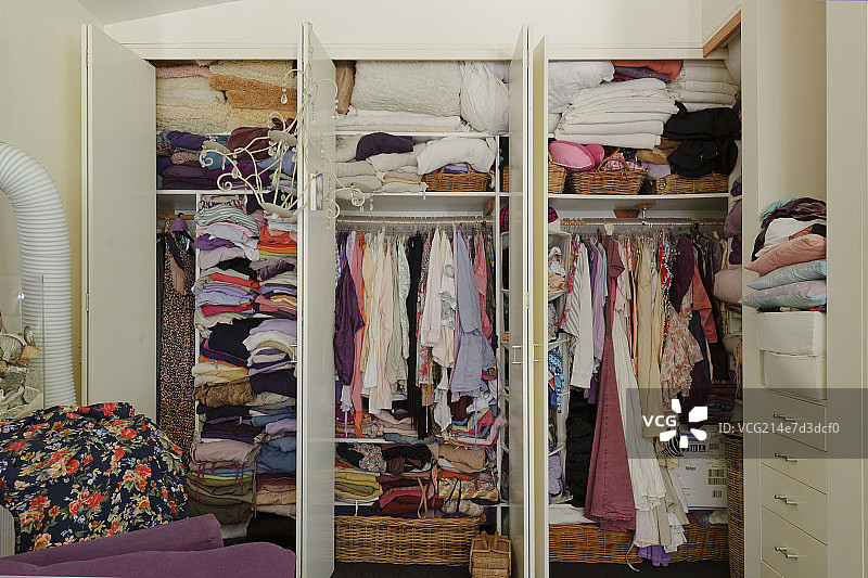 Close-up of clothes stacked in wardrobe at house图片素材