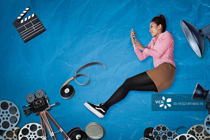 躺在蓝色雨布上的年轻女生图片素材