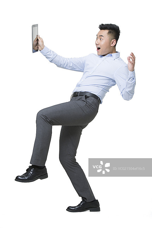 年轻商务男士吃惊地拿着平板电脑图片素材