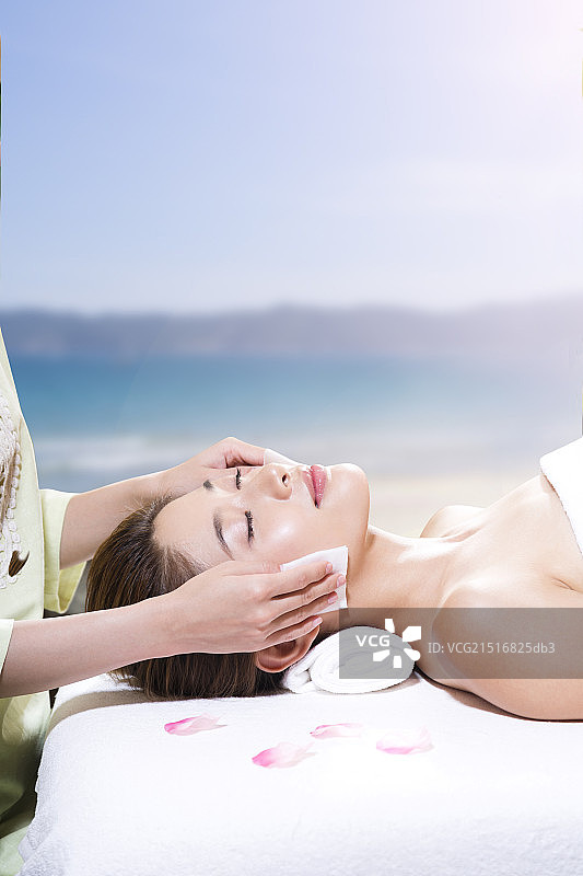年轻女人在海边做SPA美容图片素材