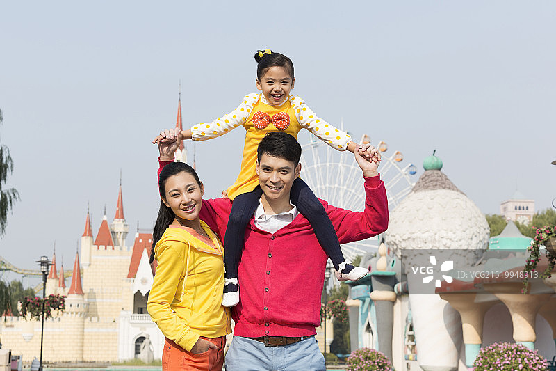 快乐的一家三口去游乐园玩图片素材