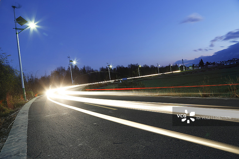 苍山下乡村公路光轨与新能源路灯图片素材
