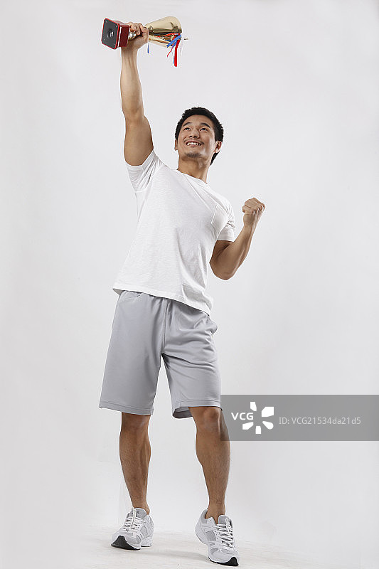 一个穿休闲装手握奖杯的青年男士图片素材