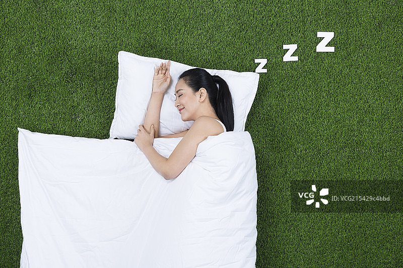 草地创意睡觉的年轻女子图片素材
