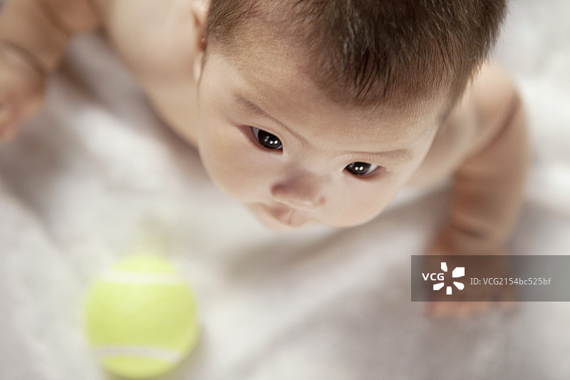 A baby watching the tennis ball图片素材