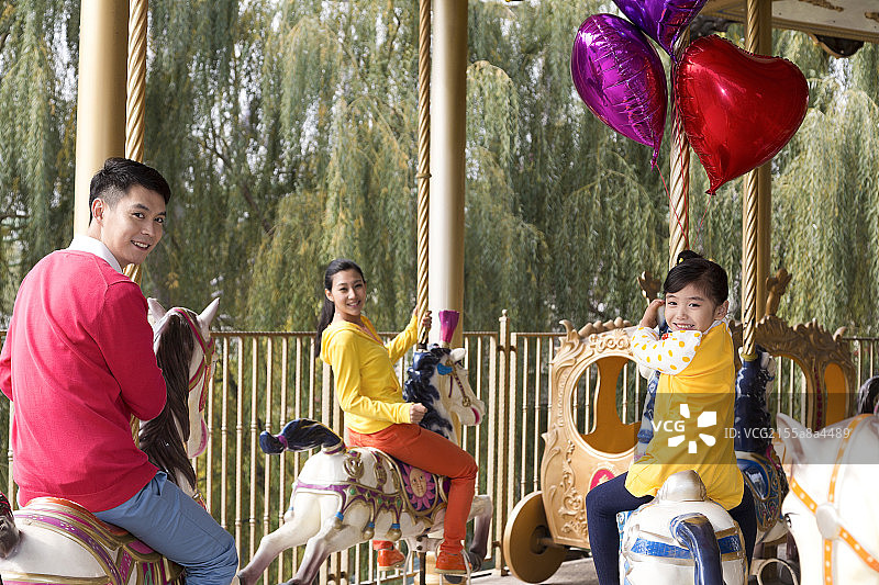 快乐的一家三口去游乐园玩图片素材