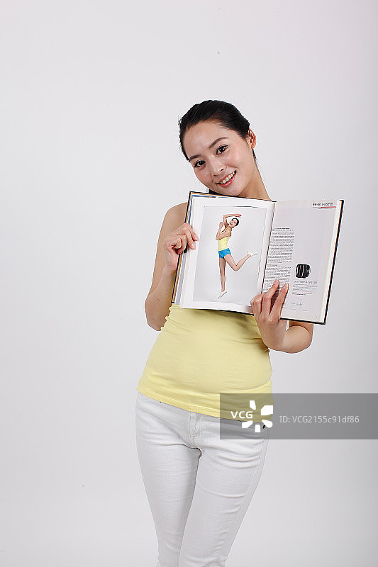 一个拿着画册的青年女性图片素材