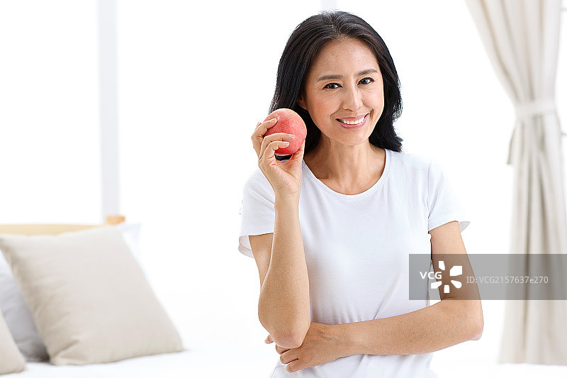 一个中年女人拿着苹果图片素材