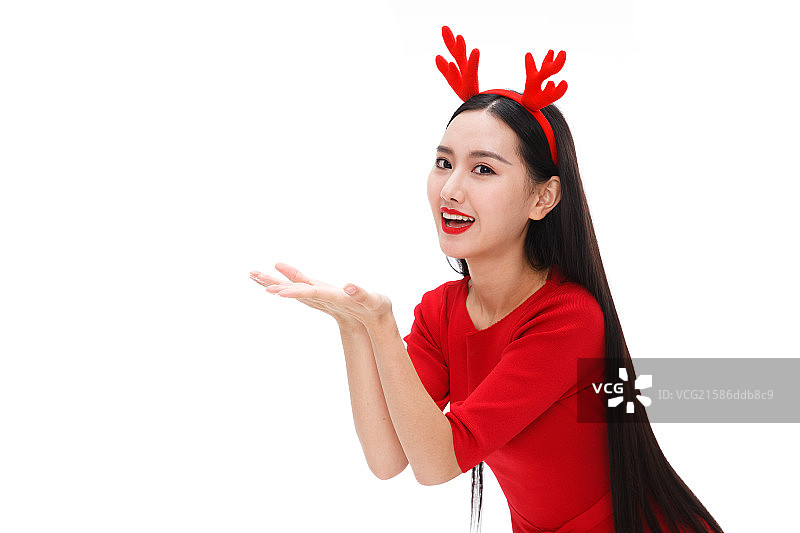 戴着圣诞头饰的青年女人做托的手势图片素材