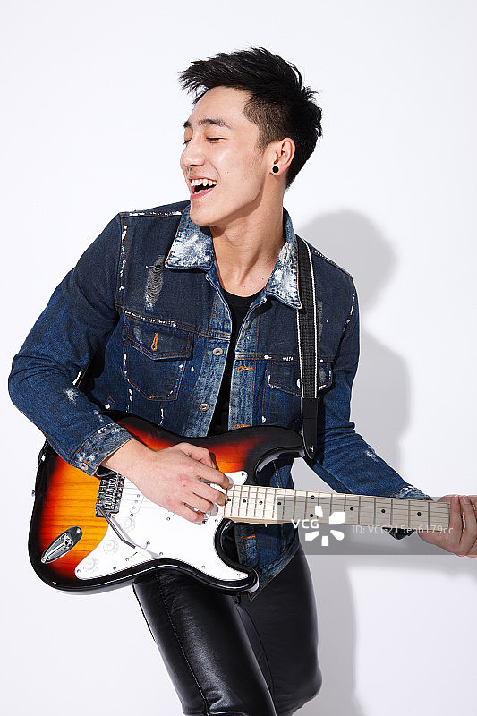 时尚的青年男人弹吉他图片素材