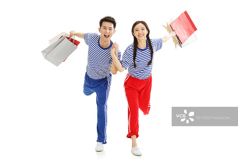拿着手提袋的青年情侣欢呼跳跃图片素材