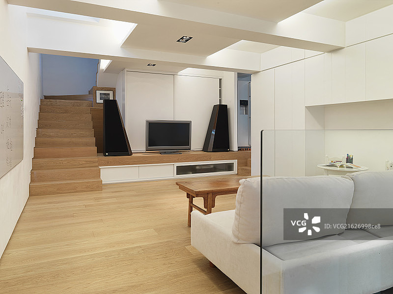 Contemporary living room wooden floor and stairs along TV with speakers,Scottsdale,USA图片素材