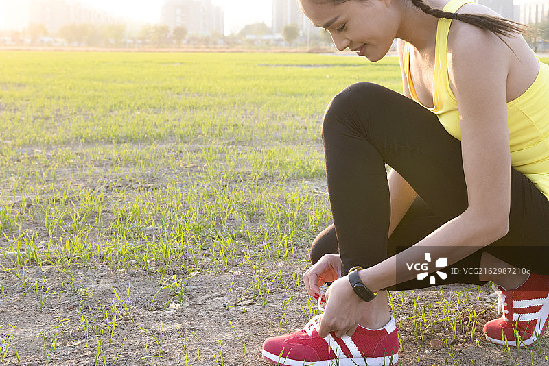 Young woman tying shoelace图片素材