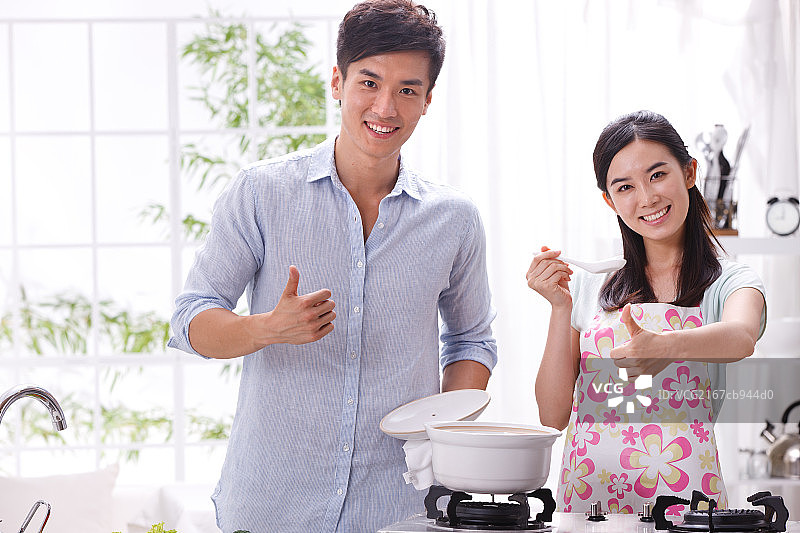 年轻夫妇在厨房做饭图片素材