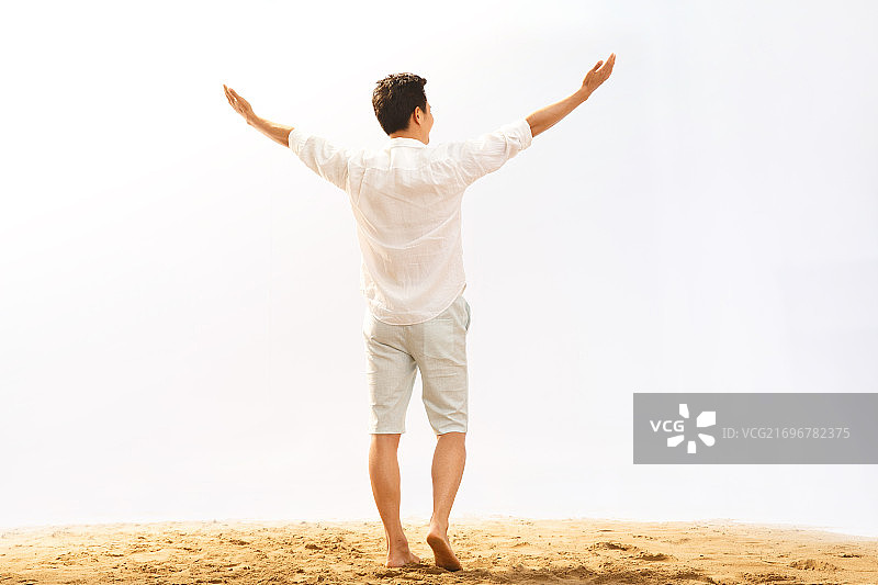 一个男人站着沙滩上图片素材