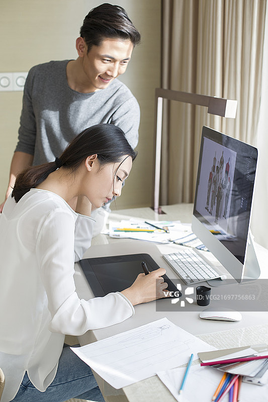 年轻服装设计师夫妇一起工作图片素材