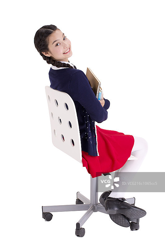 抱着书坐在椅子上的女孩图片素材