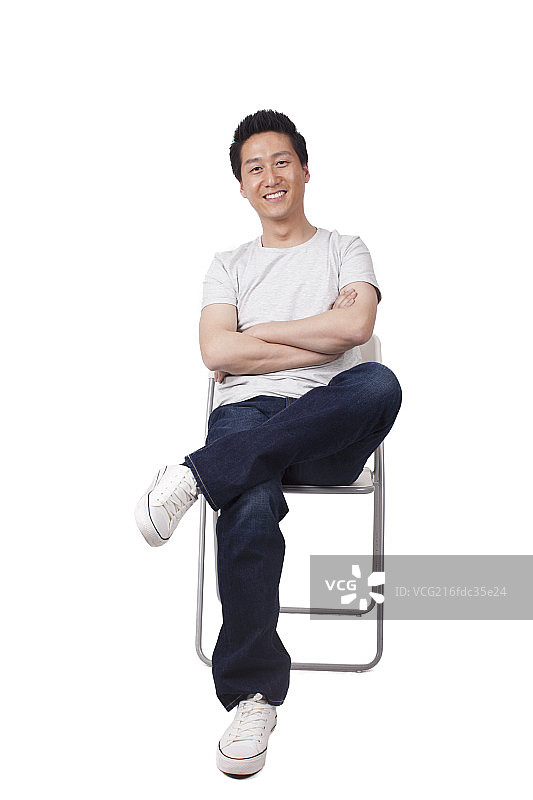 一个坐在白色折叠椅上的青年男士图片素材