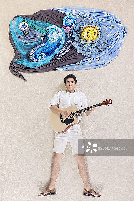 躺在地毯上手拿吉他的男士图片素材