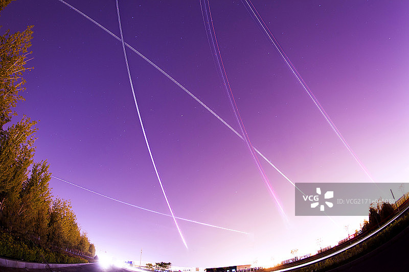 多架正在起飞中的飞机的灯光在夜空中形成了美丽的弧线图片素材