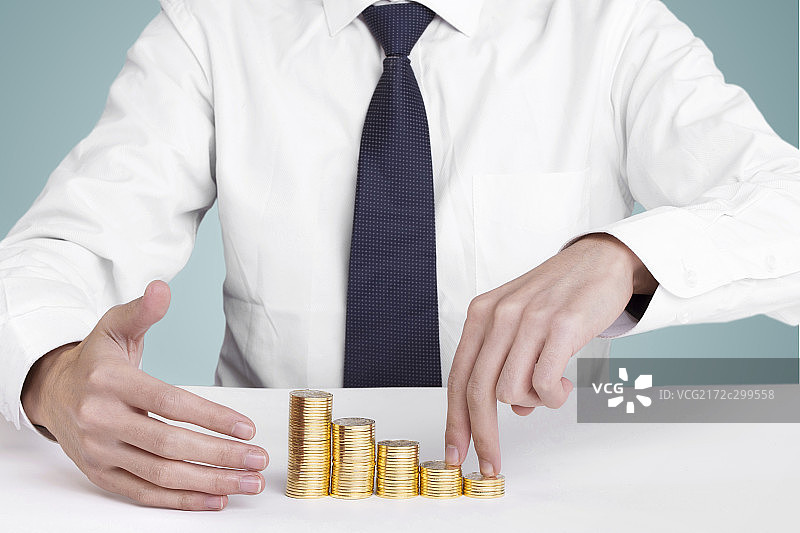 放在桌子上堆叠整齐的金色硬币图片素材