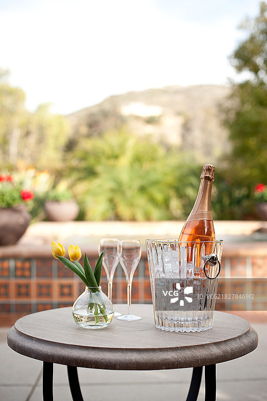 Champagne bottle and flutes on table in resort图片素材